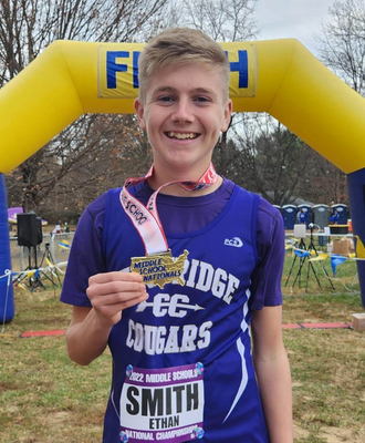  Ethan Smith holding his finishers medal after the national middle school cross country race. 